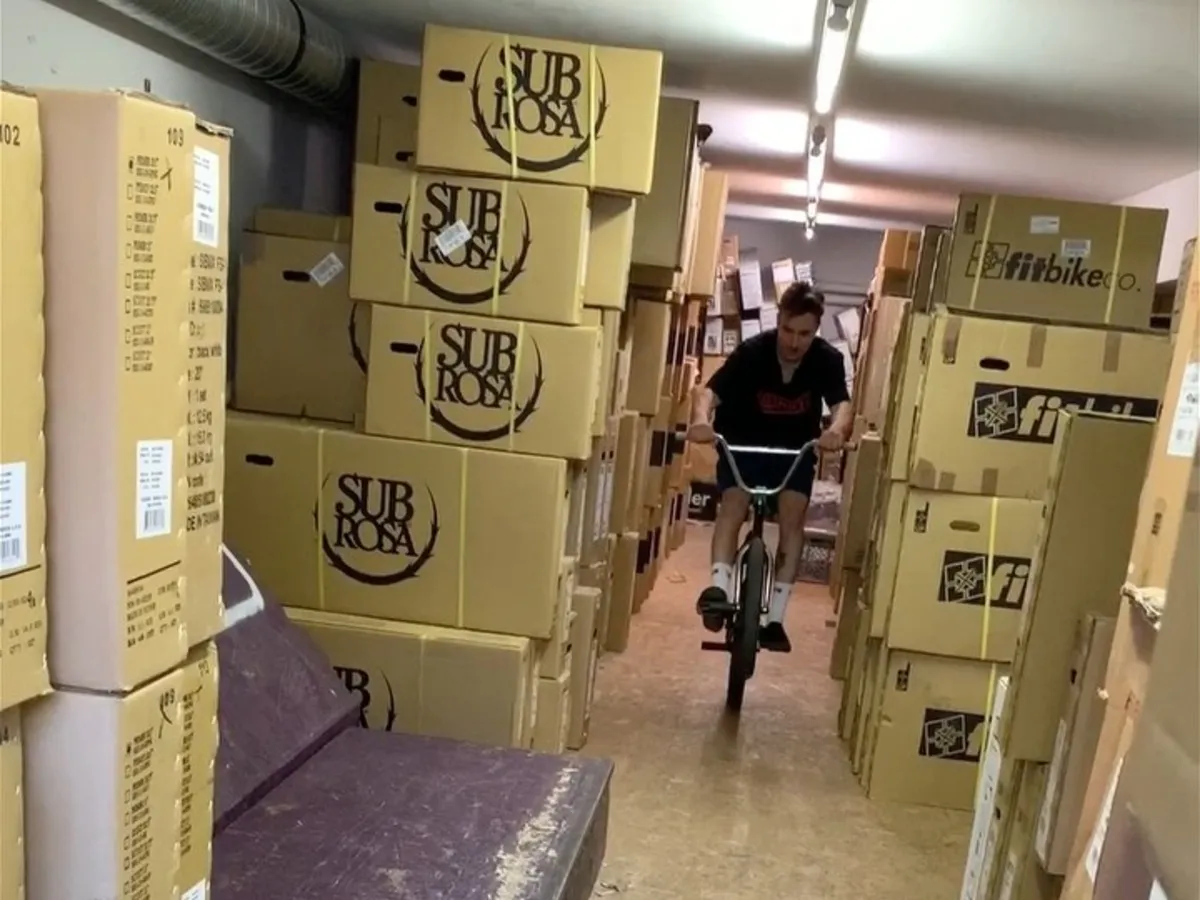 The aisle in the bike warehouse, stacked complete-bike cartons on both sides