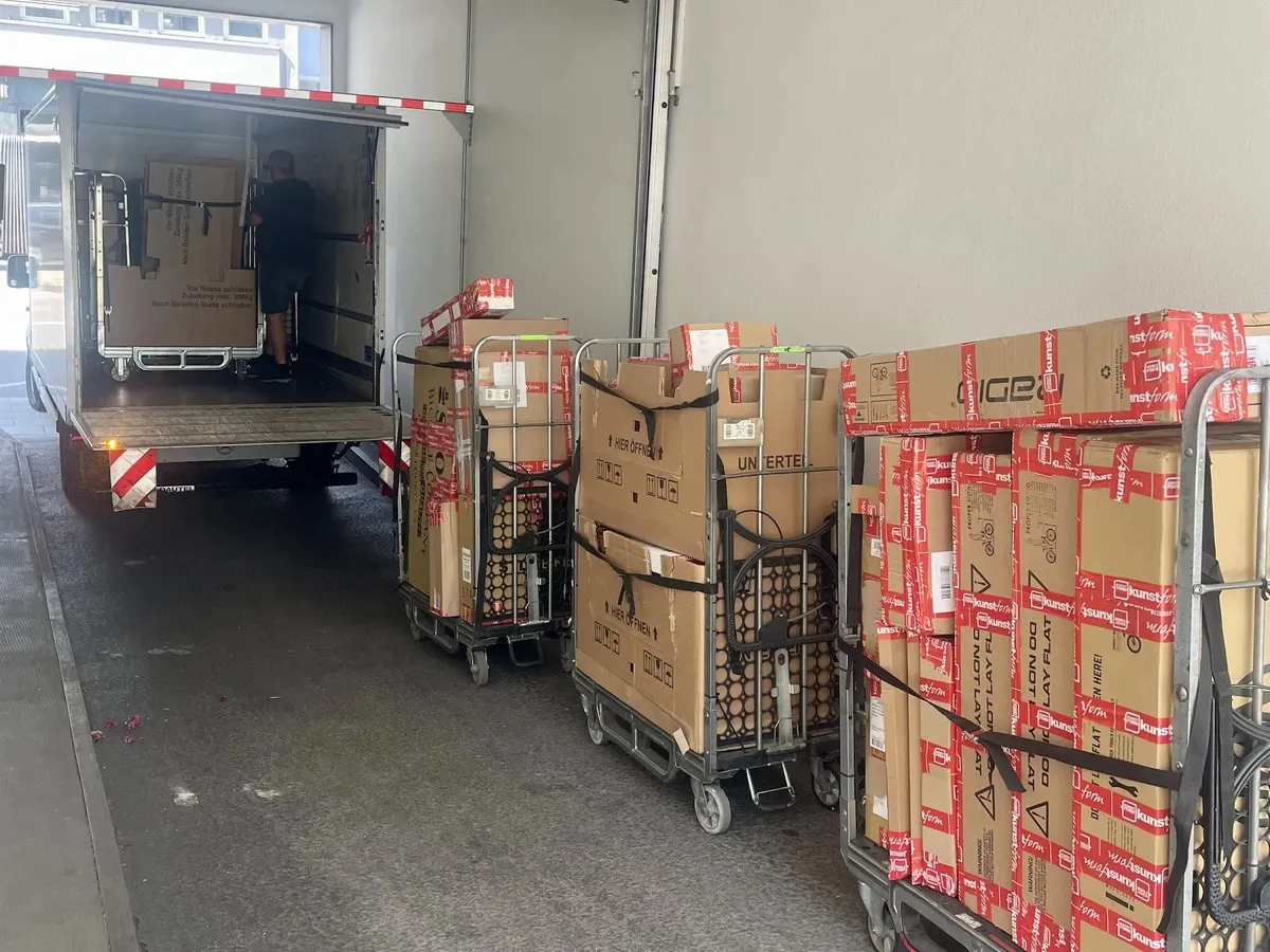 The loading bay, trolleys full of boxes beside the open lorry