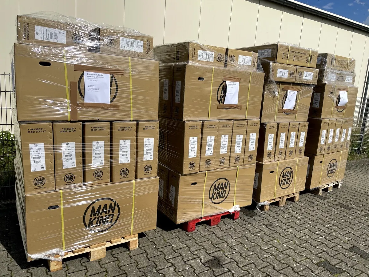 Paletten mit Kartons voller Kompletträder vor dem Haus