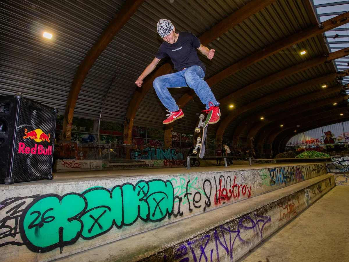Skater mit einem Trick über die Ledge neben der Red Bull Box