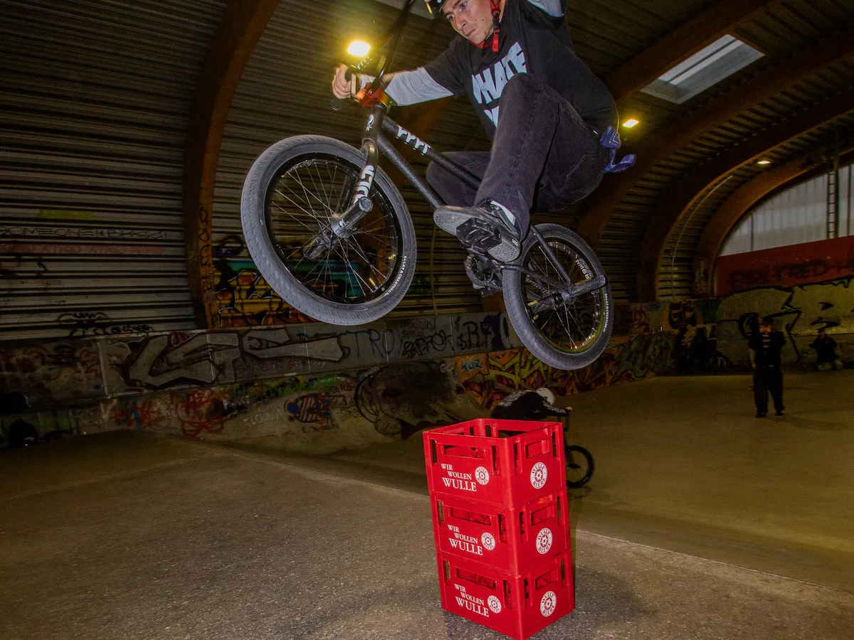 BMX Fahrer über drei gestapelte Wulle Bierkästen beim Intercités BMX Jam
